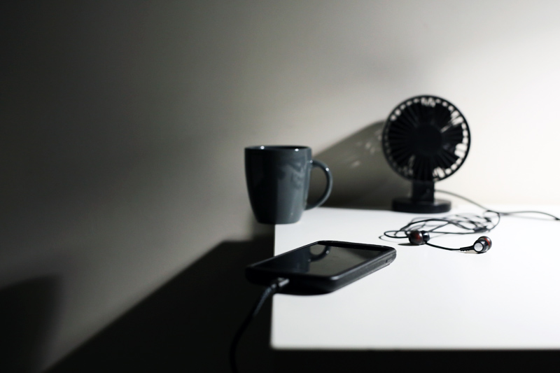 a cup of coffee, a fan and a telephone