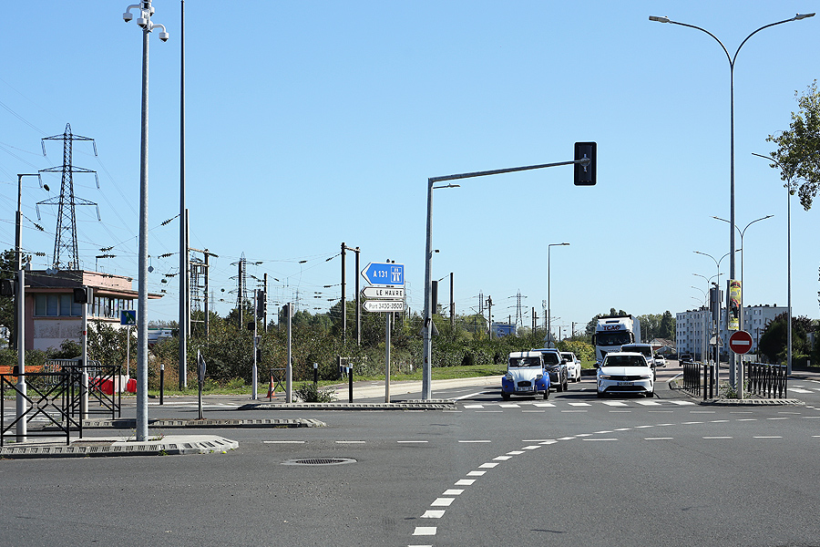 Le Havre, carrefour de l’avenue du 16ème Port, voitures à l’arrêt dont une Citroën 2 CV, dans un paysage urbain et portuaire