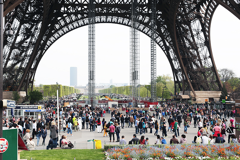 turisti e ragazze sotto la Tour Eiffel al mattino